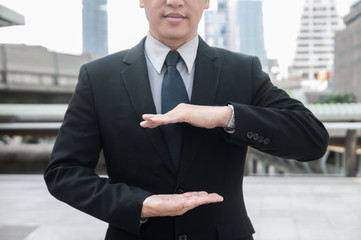 Unidentified Asian middle business man in action showing hands sign.