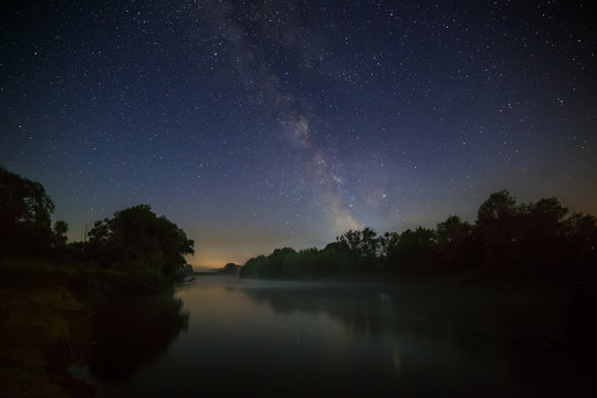 Starry night sky with the Milky Way over the river.