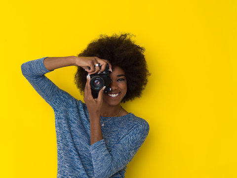 young african american girl taking photo on a retro camera