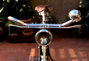 Vintage bike handlebar, with an antique light beacon, bell, brakes