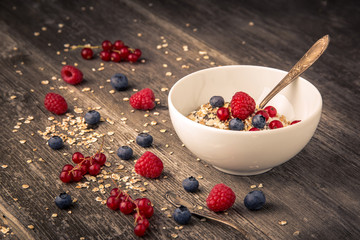 healthy breakfast with different berries and cereals on wooden background horizontal