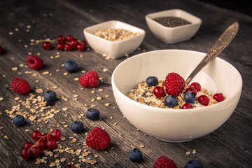 healthy breakfast with different berries and cereals on wooden background horizontal