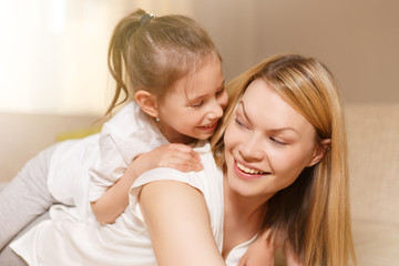 Mum and her cute daughter child girl are playing, smiling and hugging. Happy mother's day.