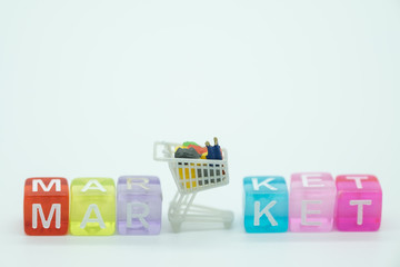 Shopping and e-commerce concept. Close up of miniature shopping carts toy figure with colorful mini letter blocks 