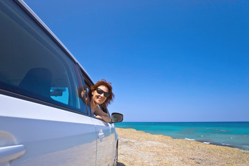 Happy woman travelling on a car .