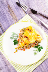 Traditional shepherd pie. Meat, potato, cheese, carrot, onion and green peas casserole. View from above, top studio shot