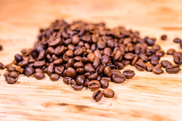 Obraz na płótnie Canvas Pile of the roasted coffee beans on wooden table