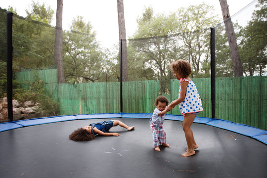 siblings playing on trampoline