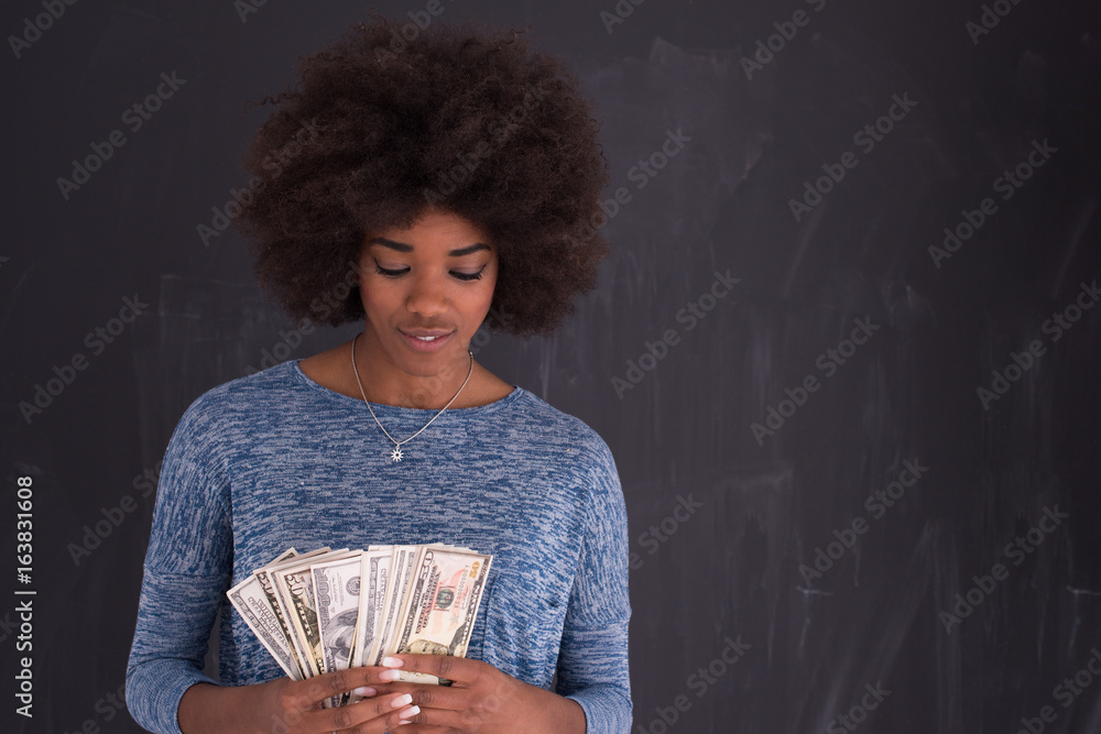 Wall mural black woman holding money on gray background