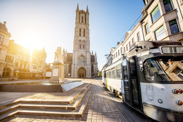 View on the saint Bavo square with cathedral and old tram during the sunrise in Gent city, Belgium