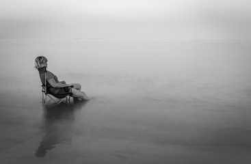 lady sitting on deck chair in the sea