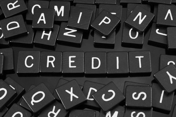 Black letter tiles spelling the word "credit" on a reflective background