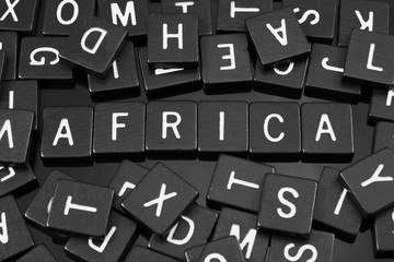 Black letter tiles spelling the word "Africa'" on a reflective background