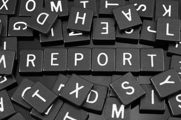 Black letter tiles spelling the word "report" on a reflective background