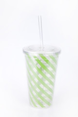 Green plastic tumbler on a white surface. Tumbler isolated on white background.