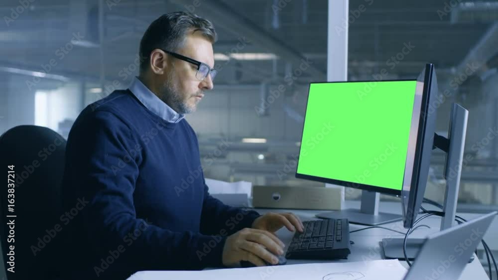 Poster chief male engineer working on technical project on his person computer. second display shows mock-u