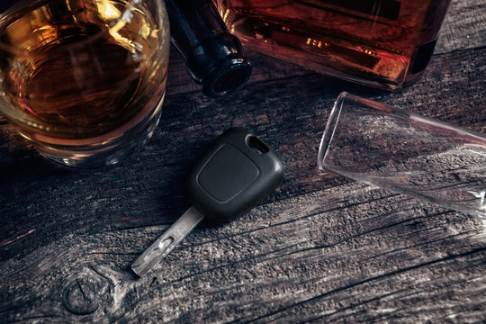 Car keys on the table with empty glass