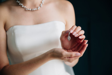 Earrind in the hands of the bride