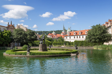Pool, statue and building at the Wallenstein (Waldstein) Garden (Valdstejnska Zahrada). It's a public Baroque garden at Lesser Town in Prague, Czech Republic. St. Nicholas Church is in the background.