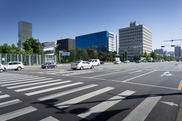 Empty pedestrian crossing in a large modern city under blue sky. Seoul, South Korea