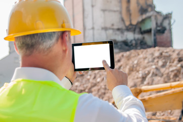 business, building, industry, technology and people concept - smiling builder in hardhat with tablet pc computer over group of builders at construction site