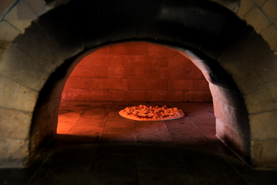 Pizza cooking in a traditional oven
