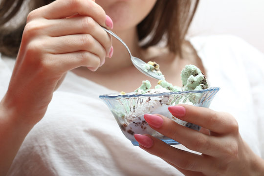 Young Woman Eating Ice Cream With Spoon