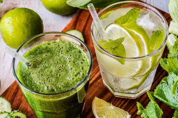 green smoothie and detox water with lime, mint and ice on wooden background. detox diet. Close-up
