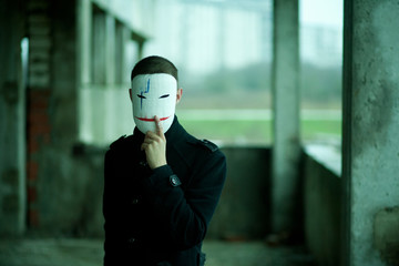 the man in black in an abandoned building in mask