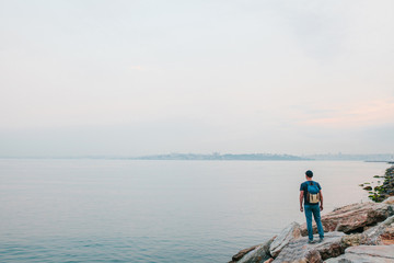 A tourist with a backpack on the coast. Travel, tourism, recreation.