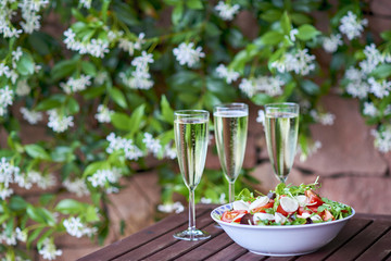 Three glassed of champagne and fresh salad