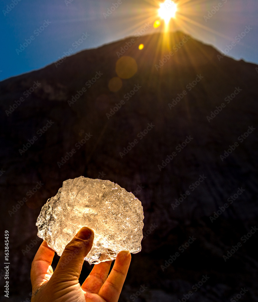 Wall mural pice of the briksdal glacier held up by hand in the setting sun in Norway