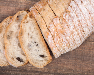 Sliced crusty ciabatta organic italian bread on wooden vintage tray