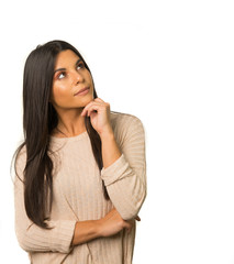 Woman looking up to side with thoughtful expression on face