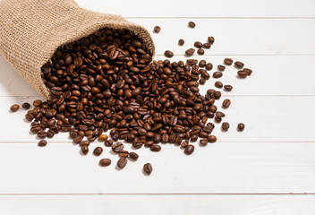 Sack of coffee beans on white table