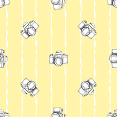 Vector seamless pattern with vintage cameras. Yellow background
