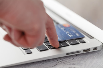Hands holding credit card and using laptop. Online shopping