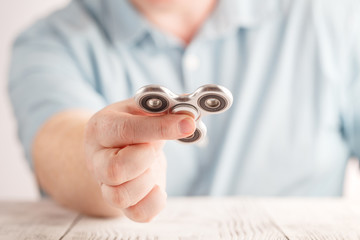 Male hand holding popular fidget spinner toy