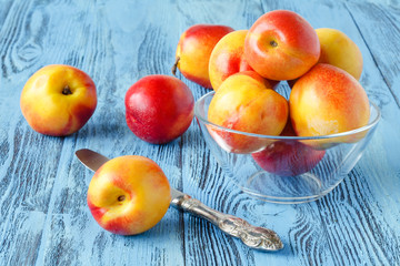 Several fresh peaches on a blue wooden background