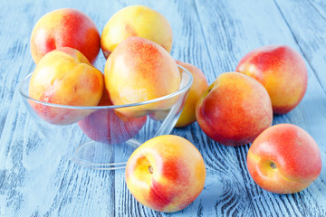 Ripe sweet nectarines on wooden table, close up