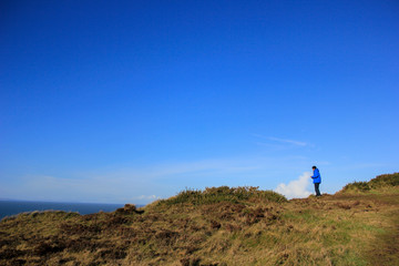 Man at hill top near the ocean