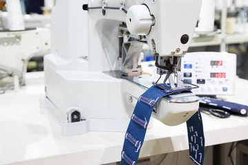 Sewing machine process a seam on jeans fabric