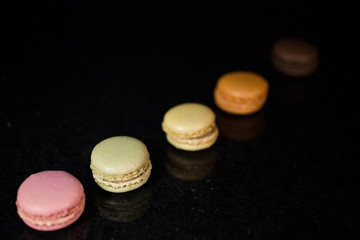 5 French Macarons on Black Granite (Diagonal Composition)