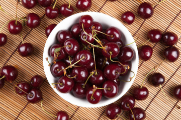 Ripe sweet cherry in a bowl on a napkin