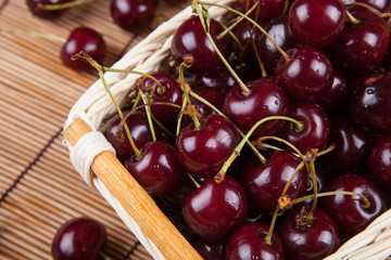 Ripe sweet cherry in the basket on a napkin
