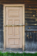 Wooden door of the old rural broken house.