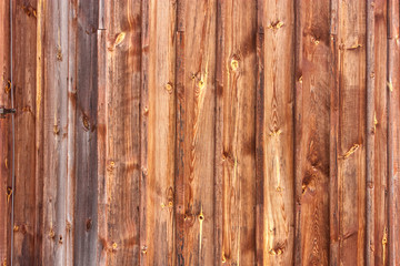 Brown background texture of vertical wooden planks logs bark.