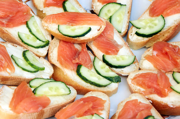 Sandwich with red fish. salmon canape on buffet table/Sandwich with smoked salmon and parsley on a plate. Elegant canape with salmon
