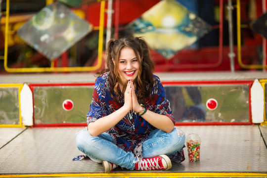 Young woman in the amusement park sitting,smiling and looking in to a camera