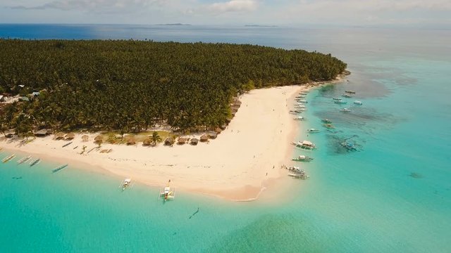 Aerial view of beautiful tropical island Daco with white sand beach. View of a nice tropical beach from the air. Beautiful sky, sea, resort. Seascape: Ocean and beautiful beach paradise. Philippines